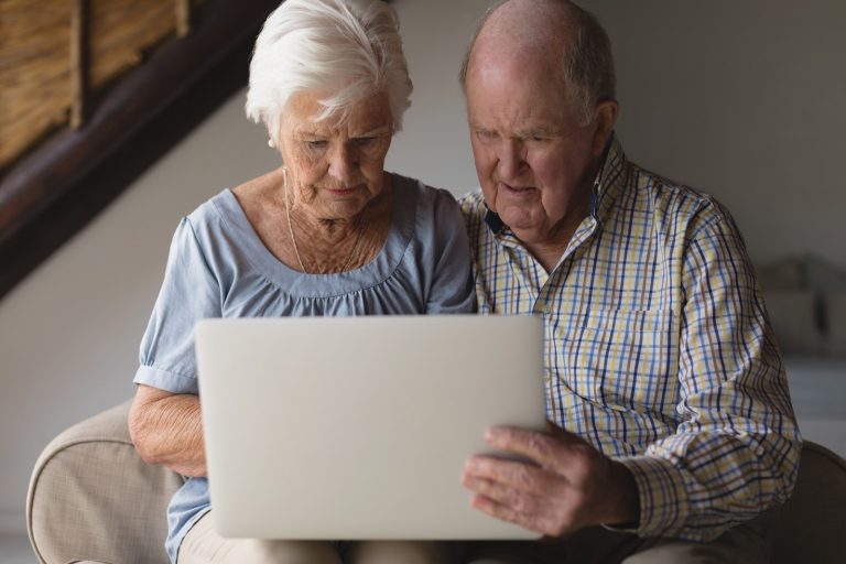senior couple reviewing finances on laptop
