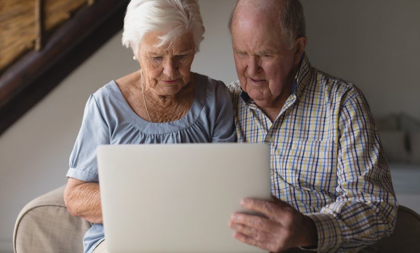 senior couple reviewing finances on laptop