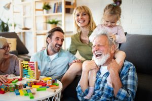 Mature grandparents playing with grandchildren and having fun with family